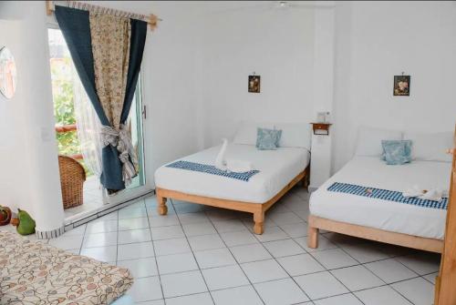 a room with two beds and a window at Las Palmas in Zihuatanejo