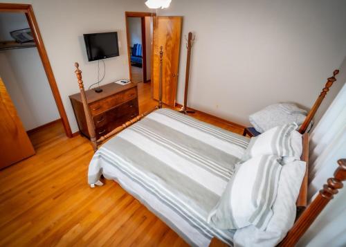 a bedroom with a bed and a dresser and a television at Amazing House Hot Tub Mins To Major Hospitals in Middle Valley
