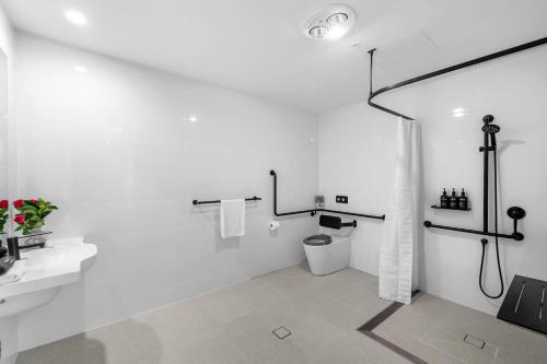 a white bathroom with a toilet and a sink at Kove Apartments Kiama in Kiama