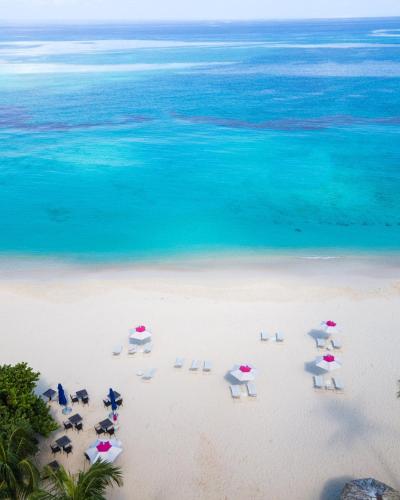 an aerial view of chairs and umbrellas on a beach at 3 SUITES AT BLUE PAVILION - 3 Apartments, 3 Kitchens - Steps to BEACH in West Bay