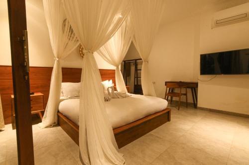 a bedroom with a bed with mosquito netting at Abinawa Hill in Lovina