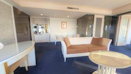 a living room with a couch and a table at Premier Hotel Nakajima Park Sapporo in Sapporo