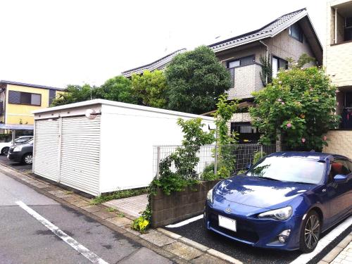 a blue car parked in front of a house at OSO Homestay in Koshigaya