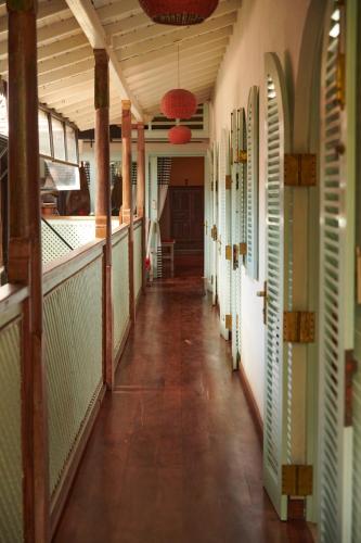 an empty hallway of a building with green shutters at LE JARDIN DU FORT - GALLE in Galle