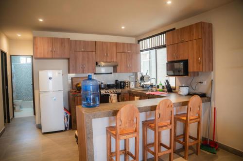 a kitchen with a counter with chairs and a refrigerator at La Vidita 891 - Piscinas, Lobitos in Lobitos