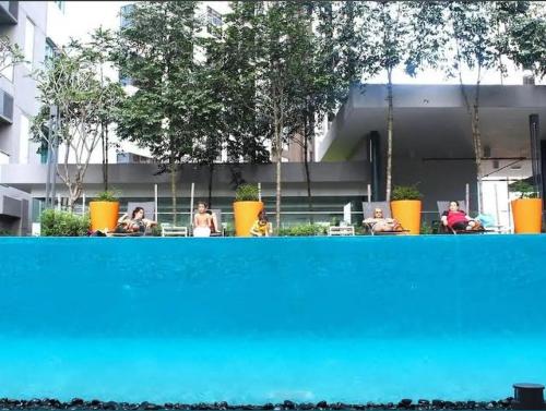 a group of people sitting at a table in front of a building at SP Home At Mercu Summer Suites in Kuala Lumpur