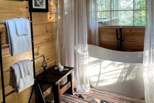 a bathroom with a shower with a window and a table at Firefly Haven - Summer Oasis with HOT TUB in Gatlinburg
