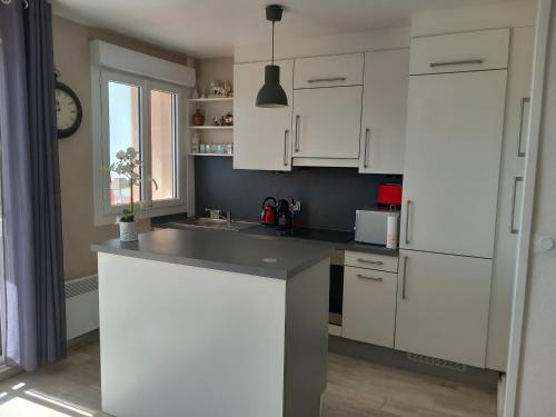 une cuisine avec des armoires blanches et un réfrigérateur blanc dans l'établissement Appartement 2 chambres avec Wi-Fi, vue mer, proche plage à Saint-Jean-de-Monts - FR-1-323-136, à Saint-Jean-de-Monts