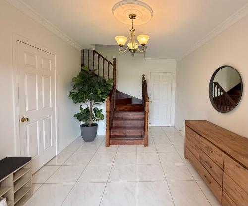 a hallway with a staircase and a mirror at Mountain Views, Spa Bath, Pet Friendly, Near Zoo! in Glass House Mountains