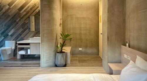 a bedroom with a bed and a bathroom with a sink at 2025 全新開幕 四蒔旅宿 Sizhu Resort in Yuchi