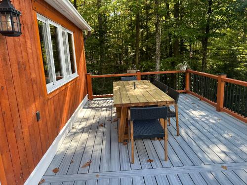 a wooden deck with a table and chairs on it at Waterville Wonderland in Thornton