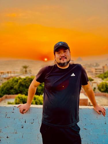 a man standing next to a blue brick wall at Akh Pyramid Hostel in Cairo
