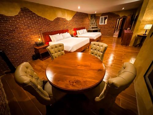 a room with a table and a bed and a bedroom at Le Suisse Spa in Santa Lucía Milpas Altas