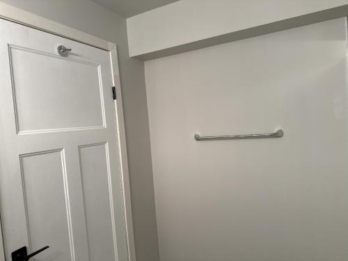 a white door with a metal handle on a wall at Luxury-Home Away from Home with Private Entrance in Winnipeg