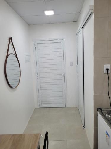 a hallway with a mirror and a white door at studio Aconchegante two in Santa Maria