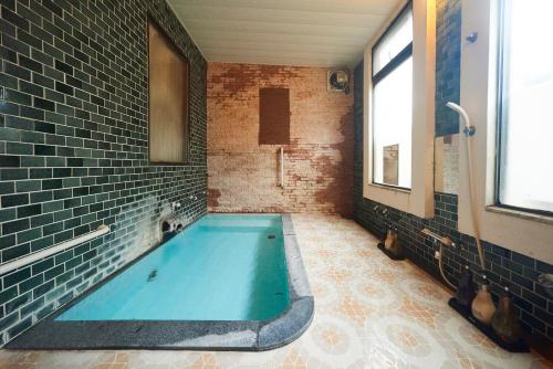 a bathroom with a large blue tub in a room at Tsukasaya Ryokan in Tsuruoka