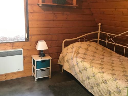 - une chambre avec un lit et une lampe sur une table de chevet dans l'établissement Grand chalet à Super Besse pour 12 pers, 4 ch, navette proche - FR-1-814-2, à Besse-et-Saint-Anastaise