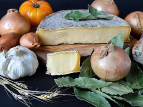 une assiette de fromage et de légumes sur une table dans l'établissement Appartement F3 confortable proche des pistes, idéal familles - FR-1-814-46, à Besse-et-Saint-Anastaise