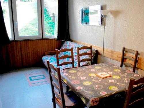 Cette petite chambre comprend une table, des chaises et un lit. dans l'établissement Confort fonctionnel, navette au pied, proche centre & pistes - FR-1-814-29, à Besse-et-Saint-Anastaise