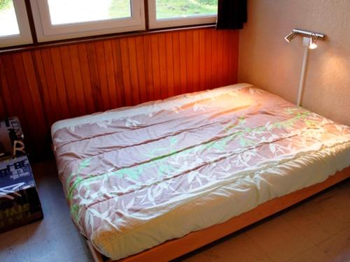 - un lit non aménagé dans une chambre avec 2 fenêtres dans l'établissement Confort fonctionnel, navette au pied, proche centre & pistes - FR-1-814-29, à Besse-et-Saint-Anastaise