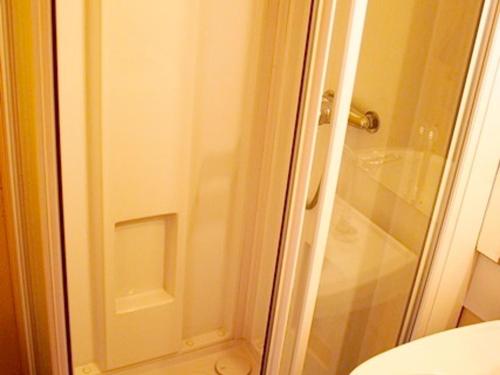 une douche avec une porte vitrée à côté des toilettes dans l'établissement Confort fonctionnel, navette au pied, proche centre & pistes - FR-1-814-29, à Besse-et-Saint-Anastaise