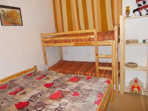 - une petite chambre avec des lits superposés et un couvre-lit dans l'établissement Appartement lumineux sud au cœur de Super Besse - FR-1-814-59, à Besse-et-Saint-Anastaise