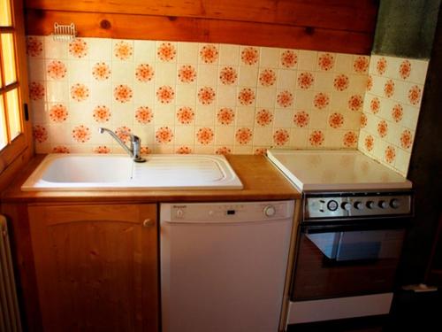 una piccola cucina con lavello e fornello di Chalet atypique près des pistes, 9 pers., sculptures uniques - FR-1-814-49 a Besse-et-Saint-Anastaise