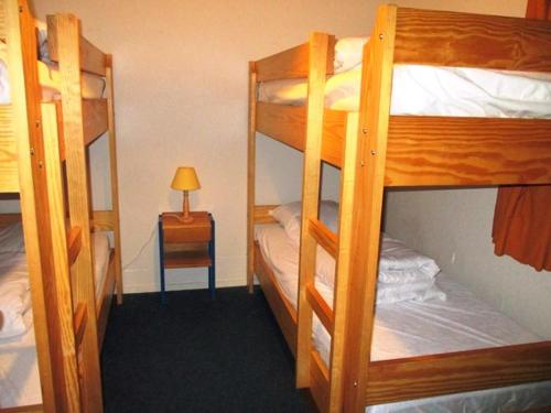 Cette chambre comprend deux lits superposés et une table avec une lampe. dans l'établissement Appartement coeur de station avec parking privé à Super Besse - FR-1-814-47, à Besse-et-Saint-Anastaise