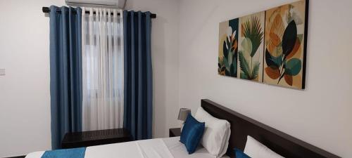 a bedroom with a bed and a picture on the wall at Sea Light Mirissa in Mirissa