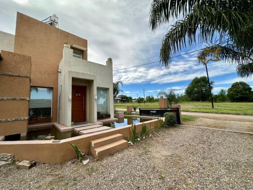 ein Haus mit einem Pool davor in der Unterkunft Apart Las Palmeras Corcovado in Villa Rumipal