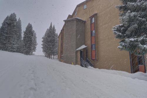 a snow covered road next to a building at CM417H Copper Mtn Inn in Copper Mountain