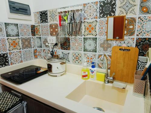 a kitchen with a counter top with a sink and tiles at Sunbeams Studio Unit in Lapu Lapu City