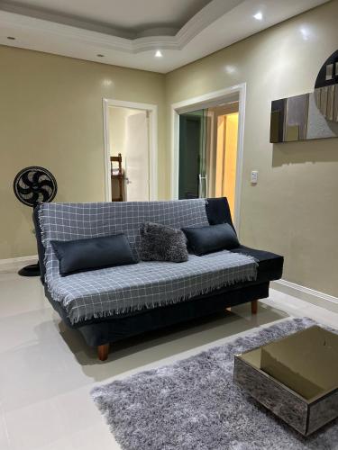 a black couch in a living room with a table at Casa de Temporada Laguna in Laguna