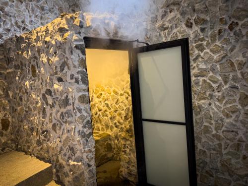 a mirror in a room with a stone wall at Le Suisse Spa in Santa Lucía Milpas Altas