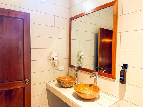 a bathroom with a sink and a mirror at Le Suisse Spa in Santa Lucía Milpas Altas