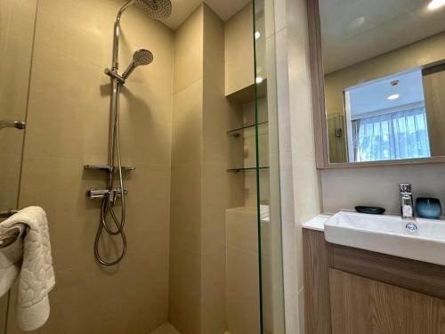 une salle de bain avec douche et lavabo dans l'établissement 2 BD Skypark Condo with Terrace, à Laguna Phuket