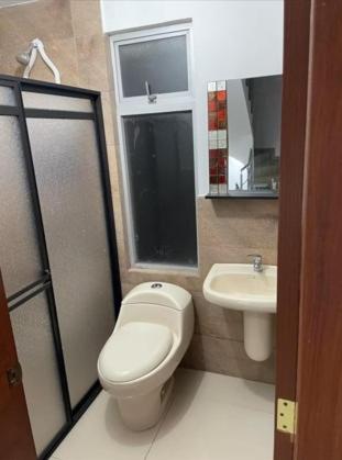 a bathroom with a toilet and a sink at Aeropuerto Internacional Quito Habitacion 1 in Quito