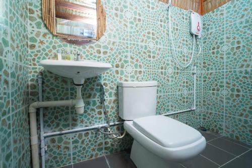 a bathroom with a toilet and a sink at 9 huts on a hill in Kudat