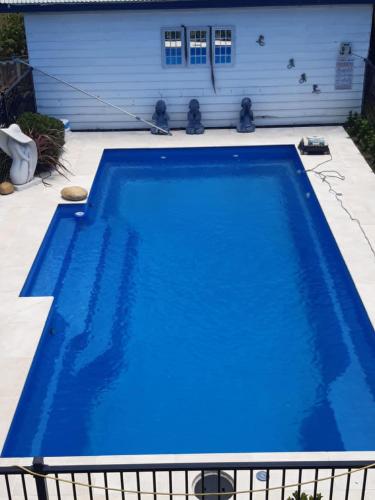 una piscina azul frente a una casa en Rae's on Beach, en Harrington