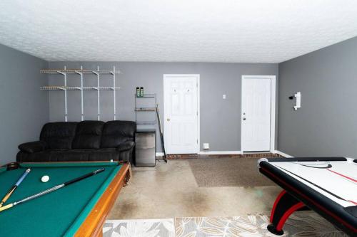 a living room with a pool table and a couch at Family Fun house with pool and games in Cataula