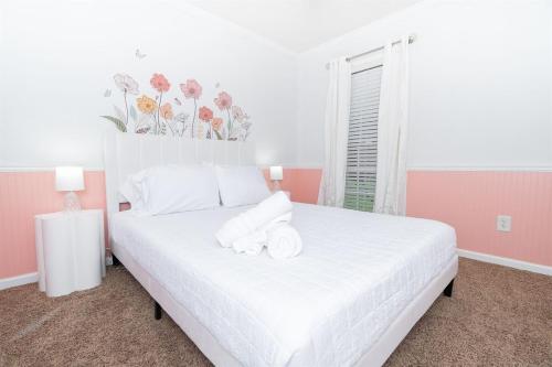 a bedroom with a white bed with towels on it at Family Fun house with pool and games in Cataula