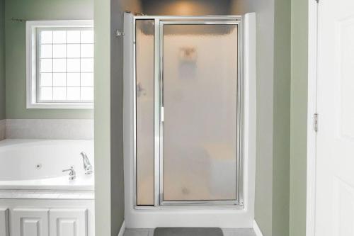 a shower with a glass door in a bathroom at Family Fun house with pool and games in Cataula