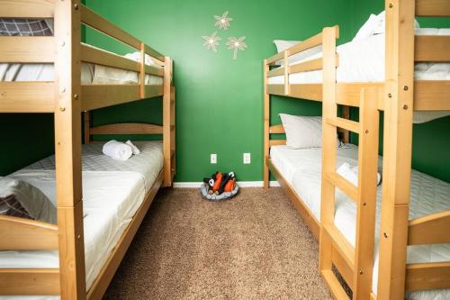 two bunk beds in a room with green walls at Family Fun house with pool and games in Cataula