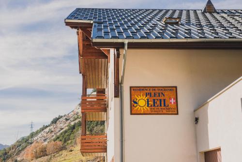 a sign on the side of a building with a roof at Résidence Plein Soleil in Avrieux