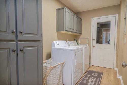 a laundry room with a washing machine and a door at Ultimate Getaway with Pool and Games in Columbus