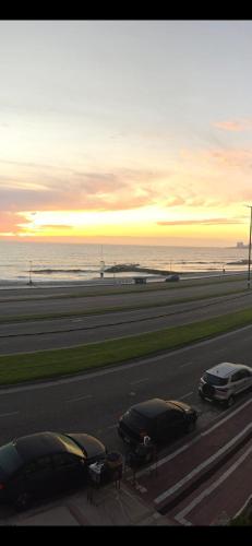 two cars parked on the side of a road near the beach at Dpto Unzue in Mar del Plata