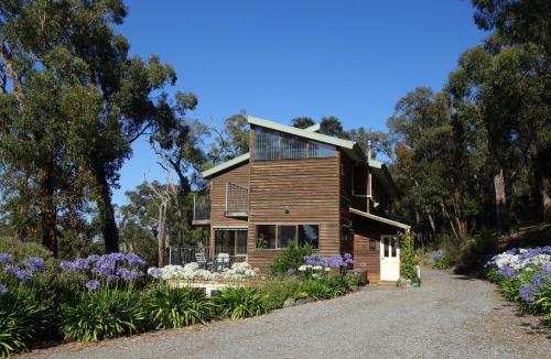 a wooden house with a garden in front of it at Queen Room with Balcony - Kookaburra Retreat Homestay in Pakenham