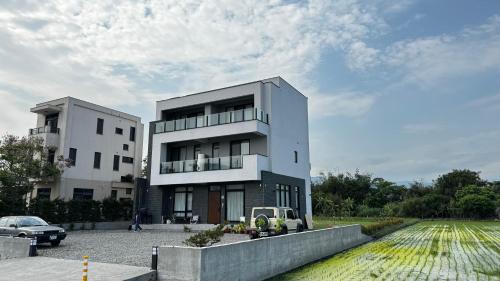 a building with a car parked in front of it at 全新根本家民宿 寵物友善 電動麻將 兒童遊戲區 廚房 in Sanxing