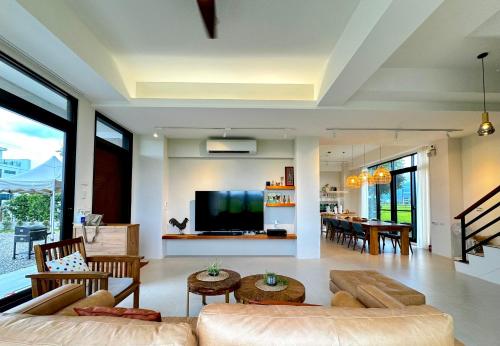 a living room with a couch and a tv at 全新根本家民宿 寵物友善 電動麻將 兒童遊戲區 廚房 in Sanxing