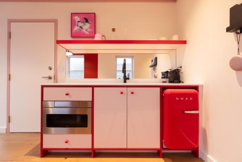 a red and white kitchen with a red refrigerator at Ode in Toronto